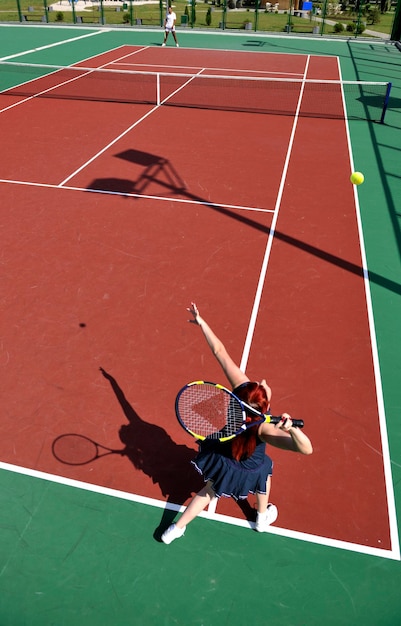 jeune femme joue au tennis à l'extérieur