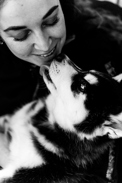 Une jeune femme joue avec un chiot husky