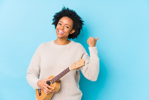 Jeune femme, jouer, ukelele, isolé, points, à, pouce pouce, loin, rire, et, insouciant