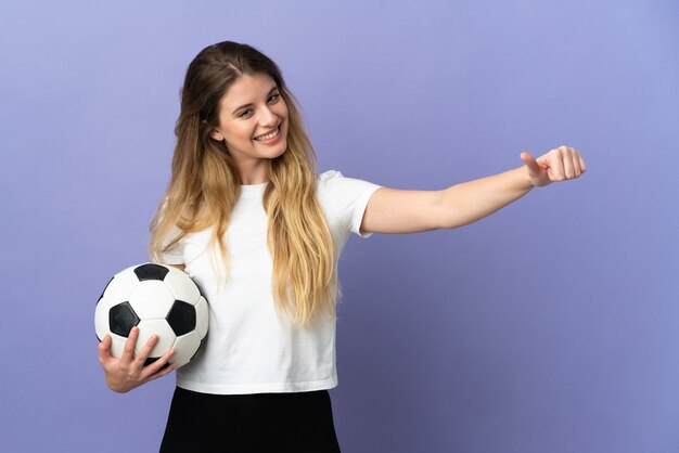 Jeune femme de joueur de football blonde isolée sur l'espace violet donnant un geste de pouce en l'air