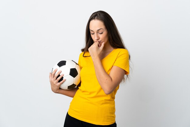 Jeune femme de joueur de football sur fond blanc isolé ayant des doutes