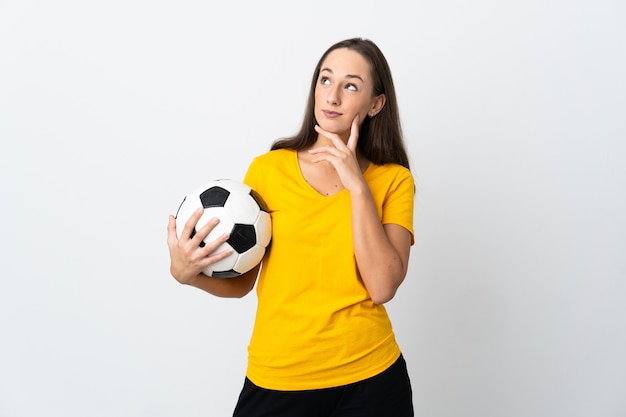 Jeune femme de joueur de football sur fond blanc isolé en pensant à une idée tout en levant les yeux