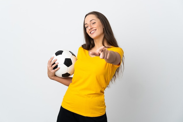 Jeune femme de joueur de football sur fond blanc isolé pointant vers l'avant avec une expression heureuse