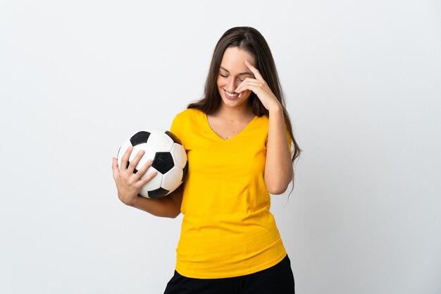 Jeune femme de joueur de football sur fond blanc isolé en riant