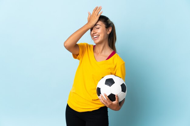 Jeune femme de joueur de football hispanique sur isolé sur mur bleu a réalisé quelque chose et l'intention de la solution