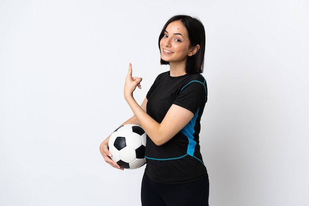 Jeune femme de joueur de football isolé sur blanc pointant vers l'arrière