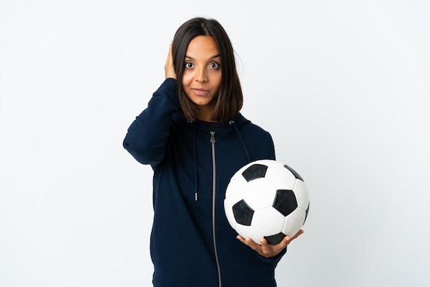 Jeune femme de joueur de football isolée sur un mur blanc frustré et couvrant les oreilles