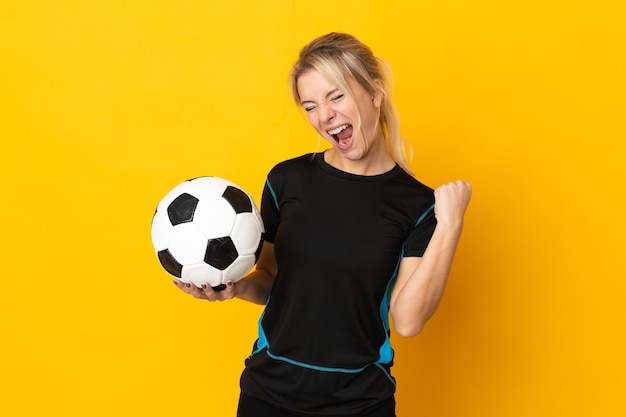 Jeune femme de joueur de football russe isolée sur fond jaune célébrant une victoire