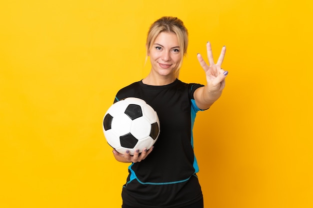 Jeune femme de joueur de football russe isolée sur fond jaune heureuse et comptant trois avec les doigts