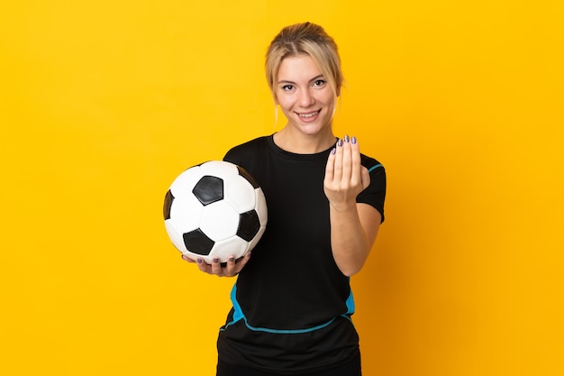 Jeune femme de joueur de football russe isolée sur fond jaune invitant à venir avec la main. Heureux que tu sois venu