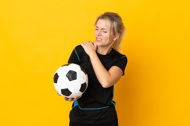 Jeune femme de joueur de football russe isolée sur jaune souffrant de douleurs à l'épaule pour avoir fait un effort