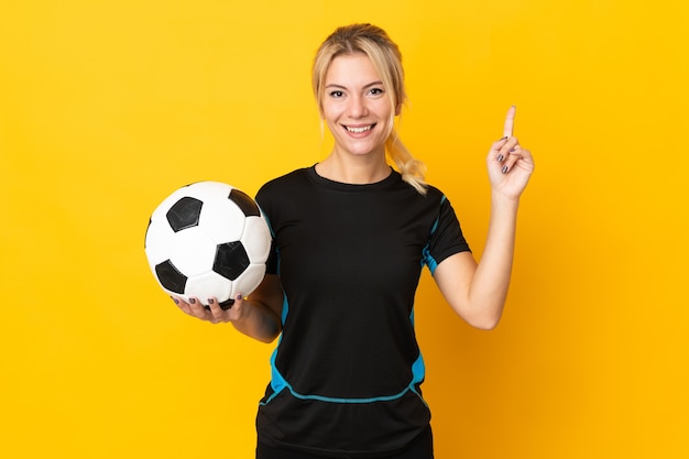 Photo jeune femme de joueur de football russe isolée sur un mur jaune pointant vers le haut une excellente idée