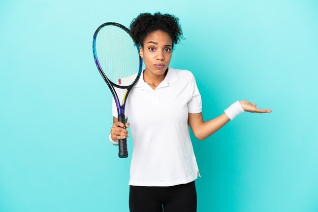 Photo jeune femme de joueur de tennis isolée sur fond bleu ayant des doutes en levant les mains