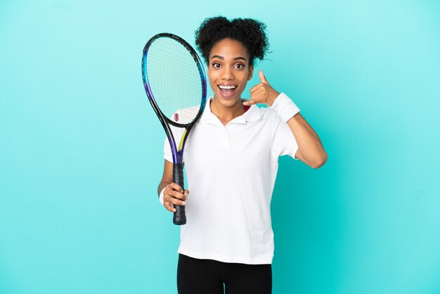 Jeune femme de joueur de tennis isolée sur fond bleu faisant un geste de téléphone. Rappelle-moi signe