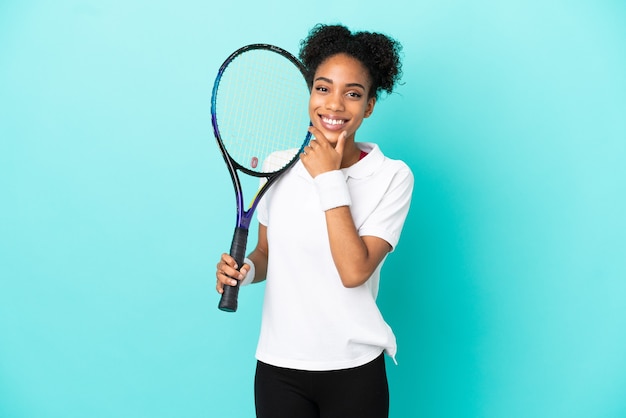 Jeune femme de joueur de tennis isolée sur fond bleu heureux et souriant
