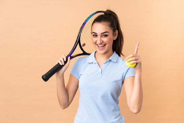 Jeune femme joueur de tennis sur mur