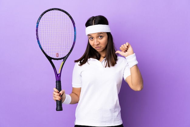 Jeune femme joueuse de tennis sur le mur fière et satisfaite