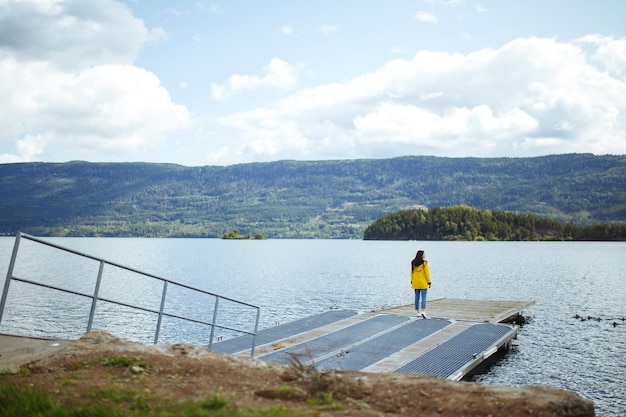 La jeune femme jouit de la liberté sur fond de montagnes en Norvège La fille touriste