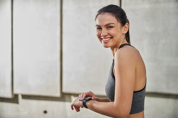 Jeune femme joyeuse démontrant son sourire tout en profitant de son activité matinale