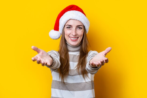 Une jeune femme joyeuse étire ses bras pour embrasser quelqu'un sur fond jaune.