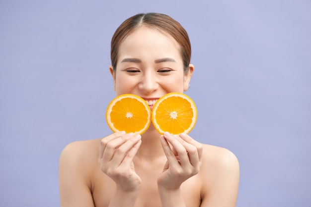 Jeune femme joyeuse avec des oranges dans ses mains