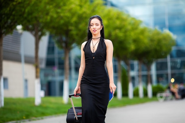 Jeune Femme Joyeuse Avec Une Valise. Le concept de voyage et de travail.