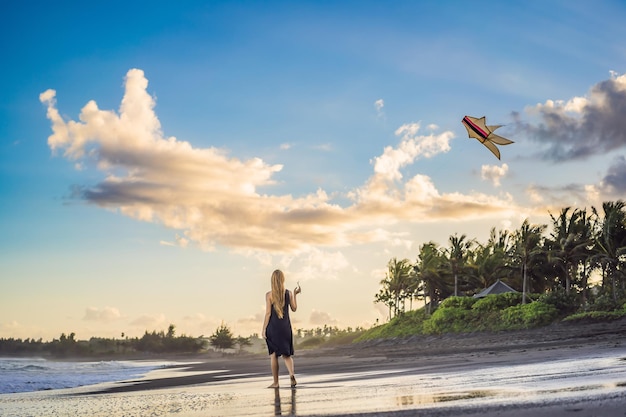 Une jeune femme lance un cerf-volant sur la plage Dream aspirations futures plans