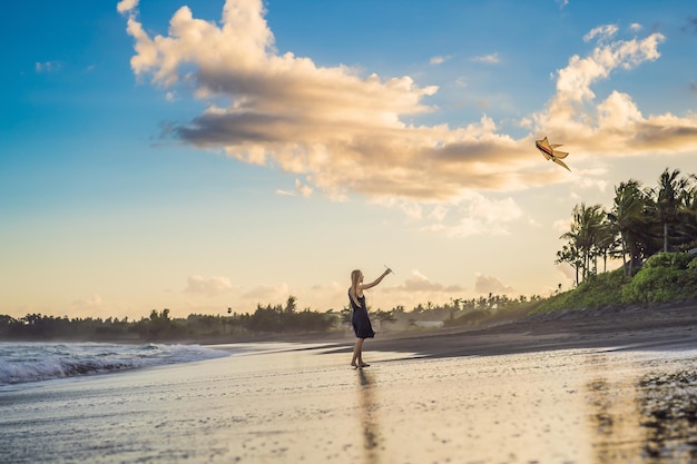 Une jeune femme lance un cerf-volant sur la plage Dream aspirations futures plans