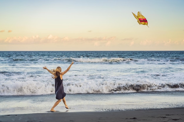 Une jeune femme lance un cerf-volant sur la plage Dream aspirations futures plans