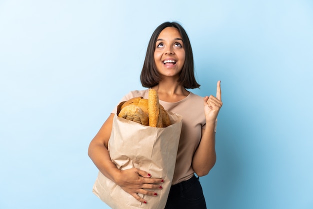 Jeune femme latine achetant des pains isolés