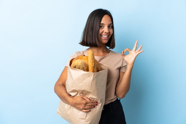 Jeune femme latine achetant des pains