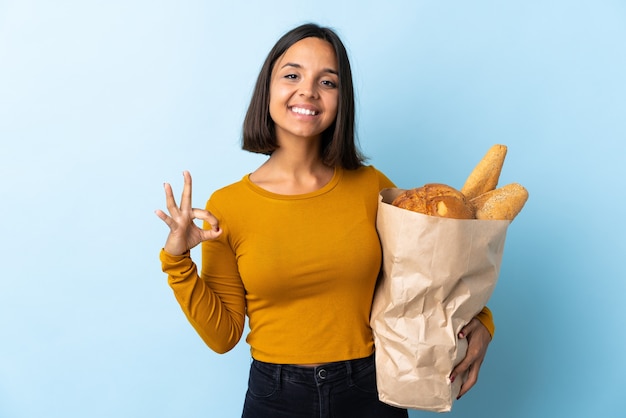 Jeune femme latine achetant des pains