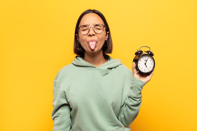 Jeune femme latine avec une attitude joyeuse, insouciante et rebelle, plaisantant et collant la langue, s'amusant