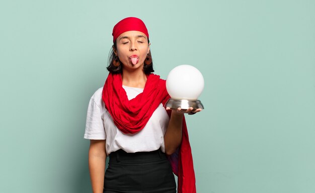 Jeune femme latine avec une attitude joyeuse, insouciante et rebelle, plaisantant et sortant la langue, s'amusant