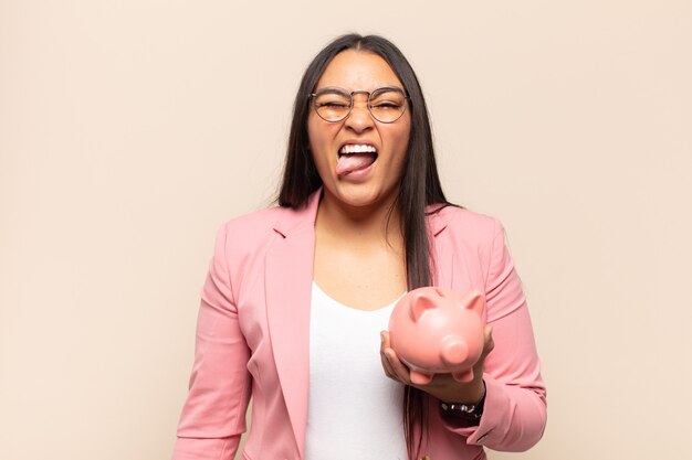 Jeune femme latine à l'attitude joyeuse, insouciante et rebelle, plaisantant et tirant la langue, s'amusant