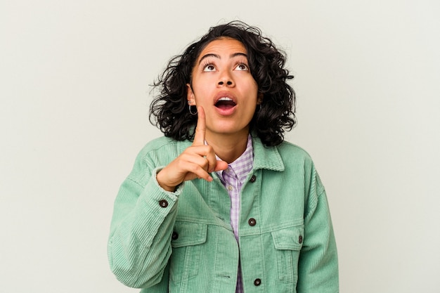 Jeune femme latine bouclée isolée sur fond blanc ayant une idée, concept d'inspiration.