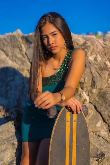 Une jeune femme latine brune avec une planche à roulettes en vacances d'été