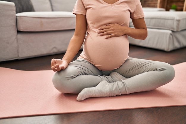 Jeune femme latine enceinte formation yoga à la maison