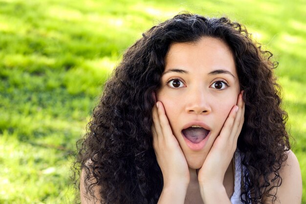 Jeune femme latine avec une expression faciale surprise.