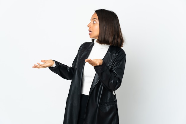 Jeune femme latine isolée sur fond blanc avec une expression de surprise tout en regardant de côté