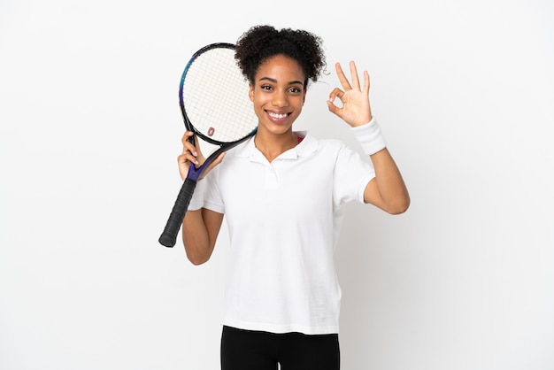 Jeune femme latine isolée sur fond blanc jouant au tennis et faisant signe OK