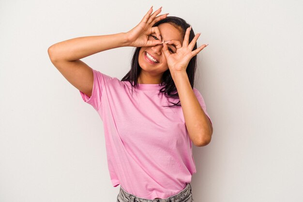 Jeune femme latine isolée sur fond blanc montrant un signe correct sur les yeux