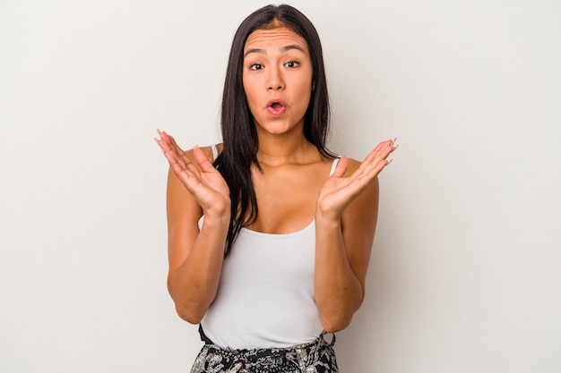 Jeune femme latine isolée sur fond blanc surprise et choquée.