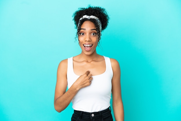 Jeune femme latine isolée sur fond bleu avec une expression faciale surprise