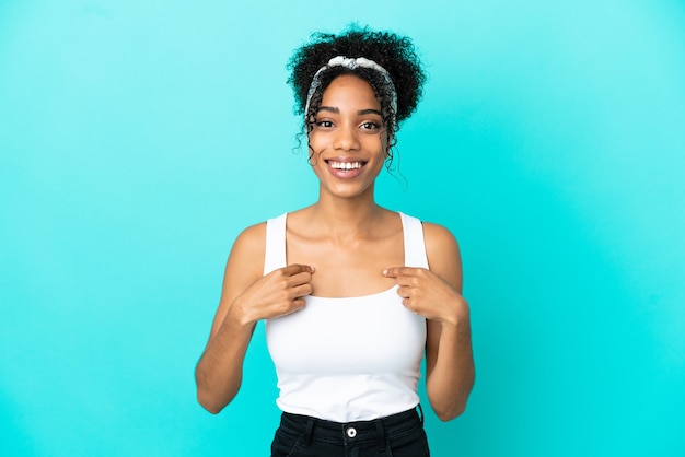 Jeune femme latine isolée sur fond bleu avec une expression faciale surprise