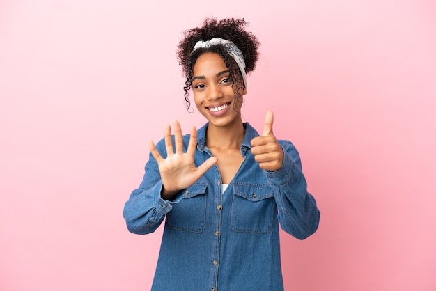 Jeune femme latine isolée sur fond rose comptant six avec les doigts