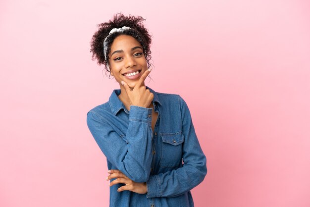 Jeune femme latine isolée sur fond rose heureuse et souriante