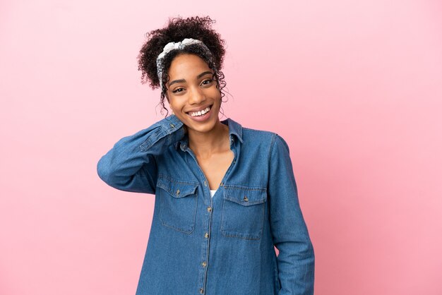 Jeune femme latine isolée sur fond rose en riant