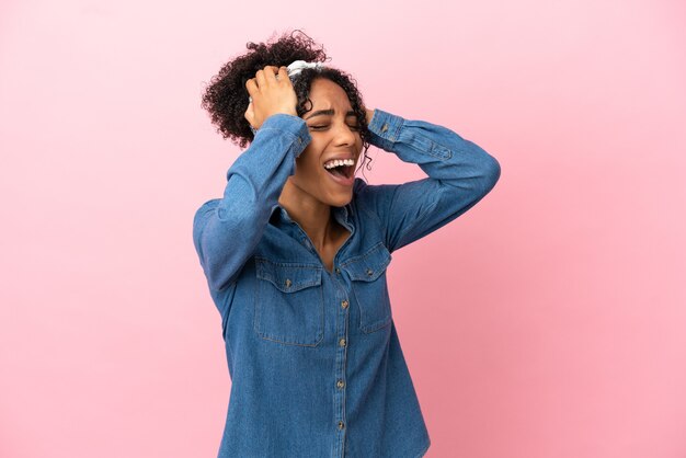 Jeune femme latine isolée sur fond rose a souligné dépassé