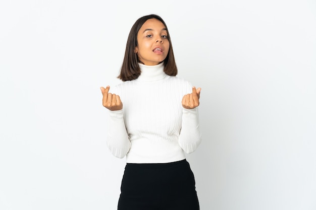 Jeune femme latine isolée sur un mur blanc faisant un geste d'argent